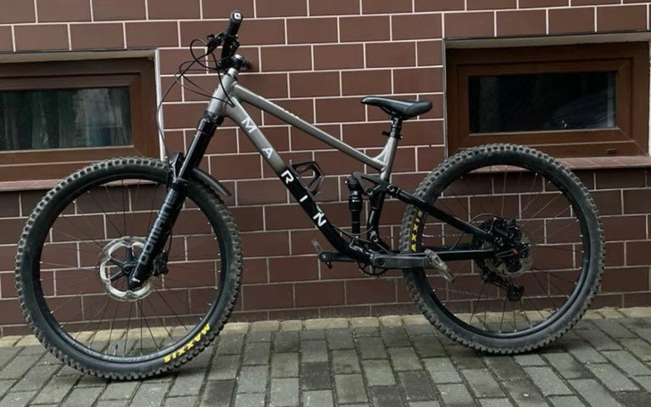 Rower górski marki Marin zaparkowany przy budynku.