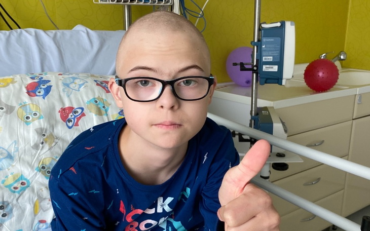 Chłopiec z okularami, uśmiechający się i pokazujący kciuk w górę.