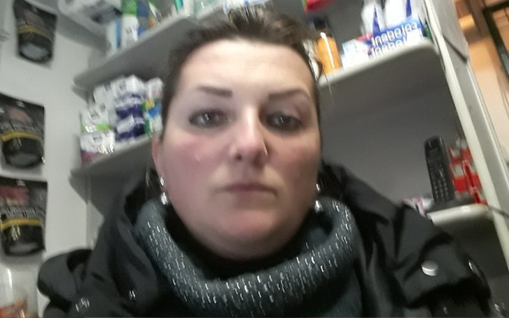 Kobieta w sklepie, z poważnym wyrazem twarzy.