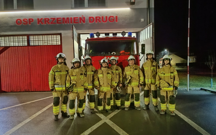 Grupa strażaków w mundurach przed remizą OSP Krzemień Drugi.