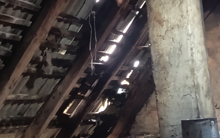 Widok na drewniany strop z promieniami światła wpadającymi przez szczeliny.