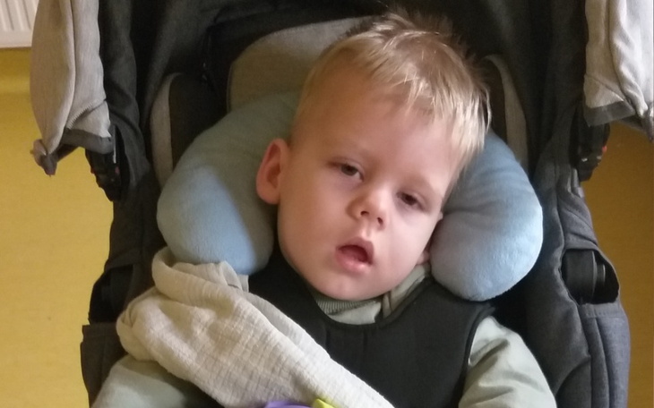Mały chłopiec w wózku, wyglądający na zmęczonego.