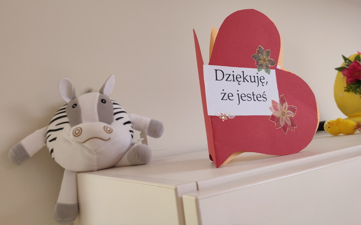 Serce z napisem 'Dziękuję, że jesteś' obok pluszowego zwierzątka.
