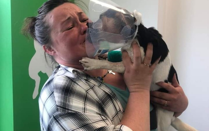 Kobieta z psem w objęciach, wyrażająca emocje.