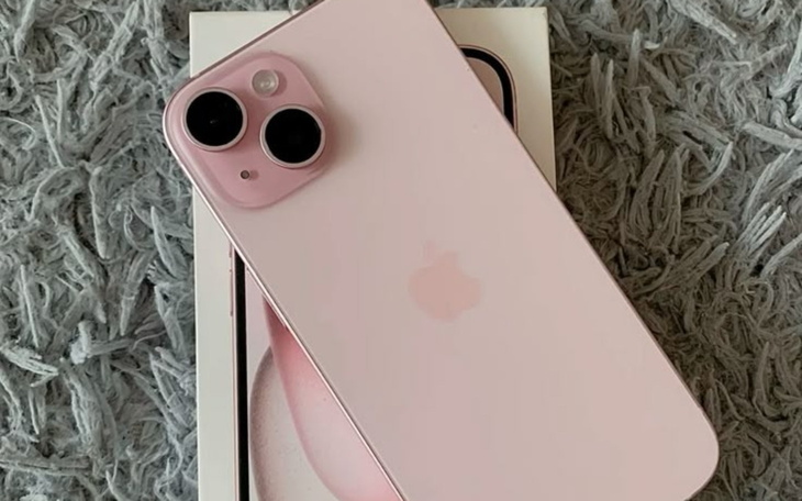 Różowy iPhone 13 na tle opakowania.