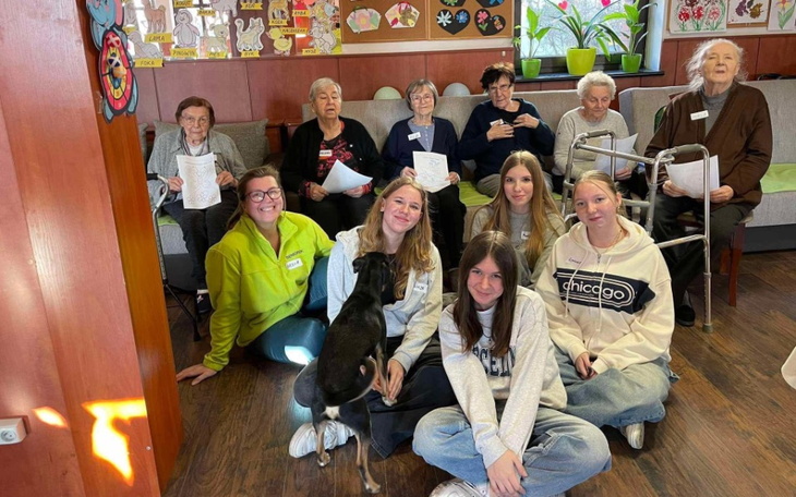 Grupa osób w ośrodku, uśmiechnięte twarze i przyjazna atmosfera.