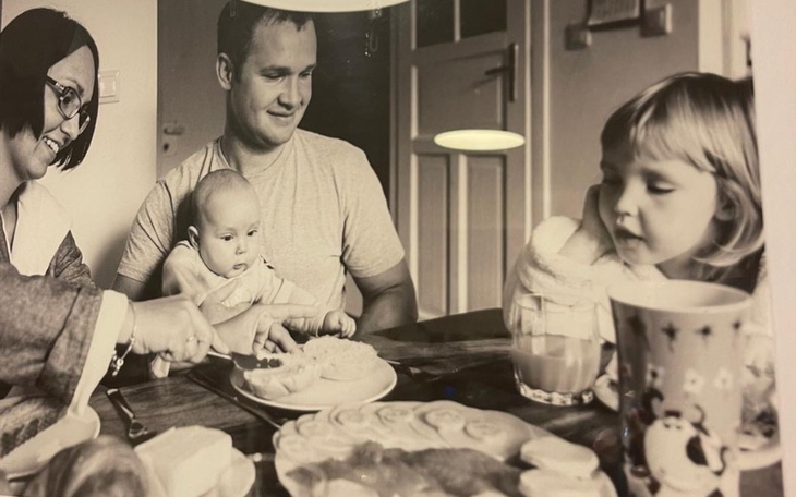 Rodzina przy stole, jedząca posiłek z dzieckiem.