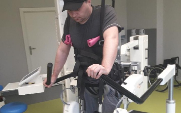 Mężczyzna korzystający z urządzenia rehabilitacyjnego w trakcie terapii.