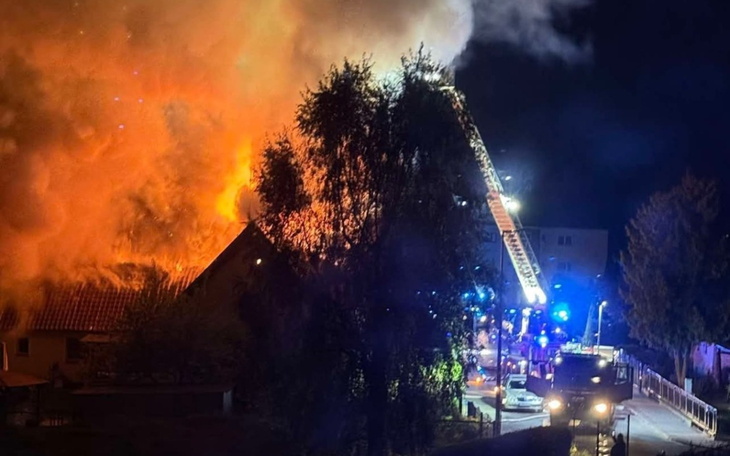 Pożar budynku z wozami strażackimi w akcji.