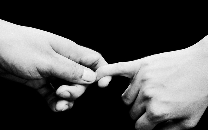 Dwie ręce łączące się w delikatnym geście.