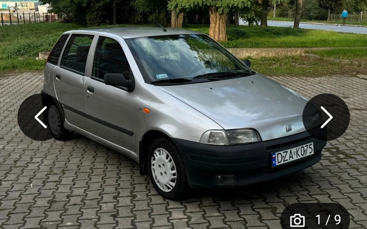 Srebrny samochód zaparkowany na kostce brukowej.