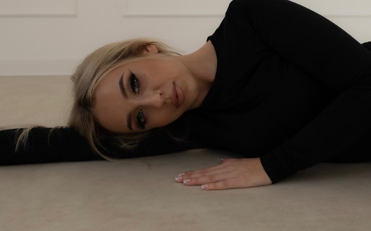 Kobieta leżąca na podłodze w czarnym stroju.