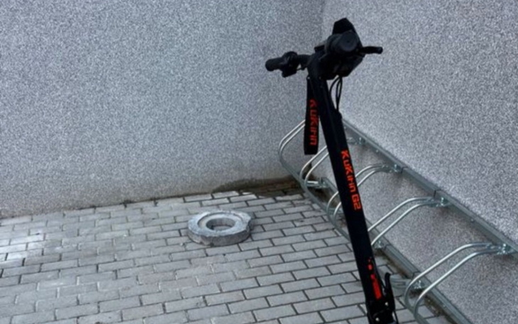 Hulajnoga elektryczna zaparkowana przy ścianie.