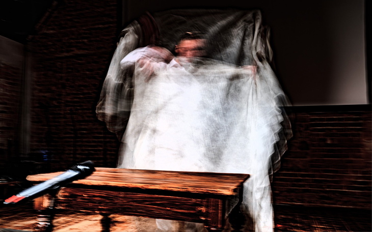 Artystyczne ujęcie osoby w białym płótnie, z mikrofonem.