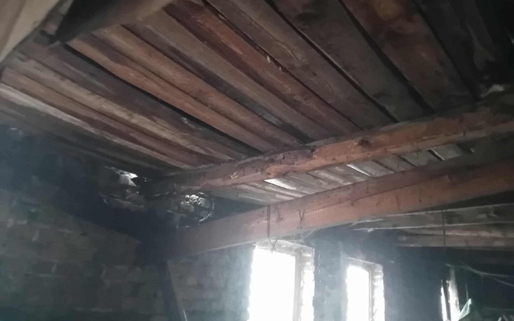 Widok na drewniany sufit w starym budynku, z widocznymi uszkodzeniami.