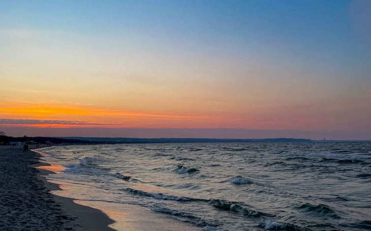 Zachód słońca nad morzem, spokojna plaża i fale.