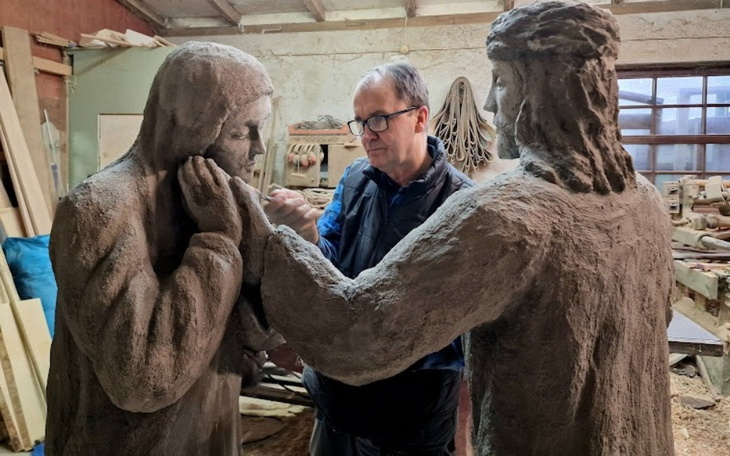 Artysta rzeźbiący postacie w glinie w warsztacie.