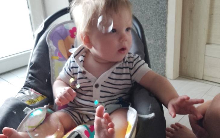 Małe dziecko bawiące się bańkami mydlanymi.