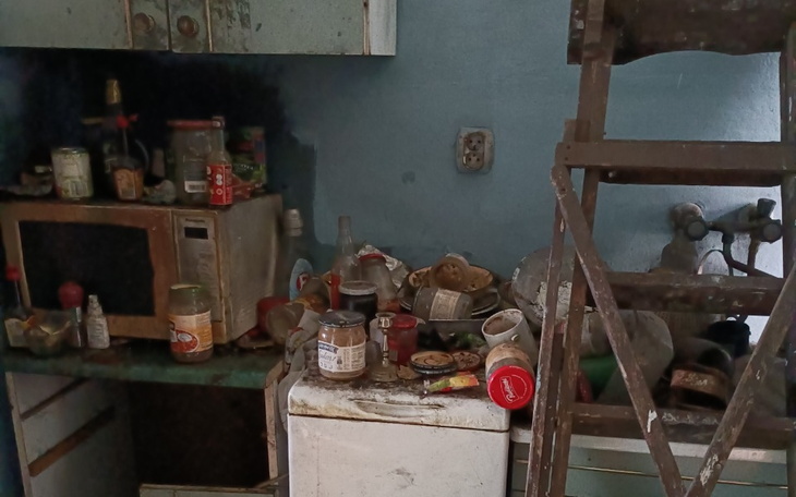 Zabałaganiona kuchnia z brudnymi naczyniami i jedzeniem.