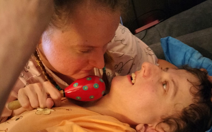 Osoba bawiąca się z dzieckiem, trzymając marakasy.