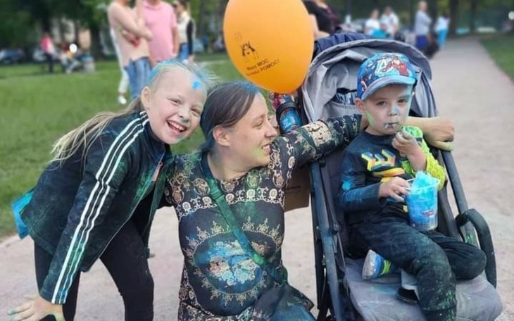 Rodzina bawiąca się na świeżym powietrzu, pokryta kolorowym proszkiem.
