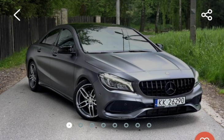 Elegancki samochód marki Mercedes zaparkowany na drodze w otoczeniu zieleni.