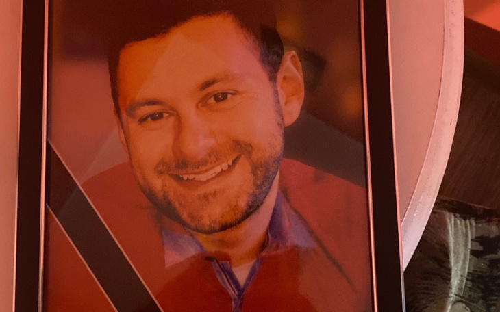 Portret mężczyzny w ramce, z uśmiechem na twarzy.