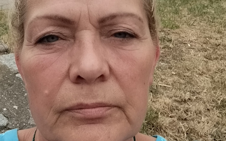 Kobieta z bliska, z poważnym wyrazem twarzy.