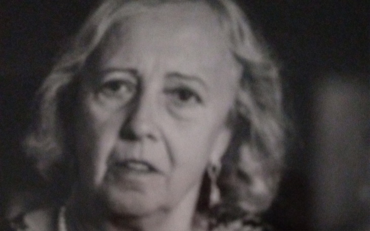 Czarna i biała fotografia kobiety, z poważnym wyrazem twarzy.