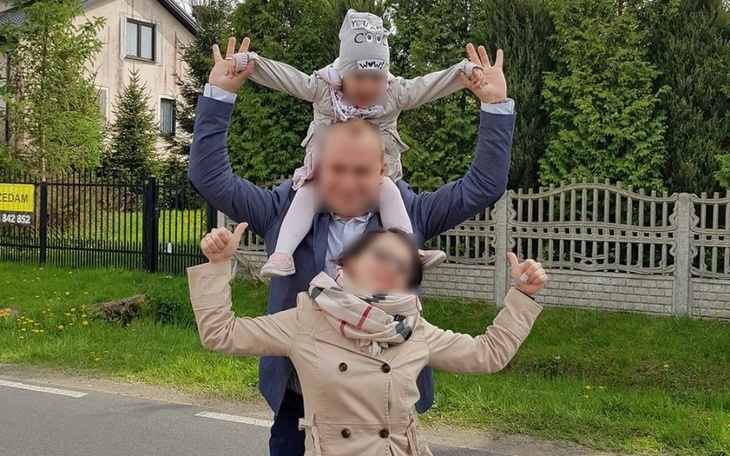 Rodzina na spacerze, dzieci na ramionach dorosłego.