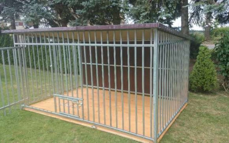 Pusty kojec dla psów na zielonej trawie.