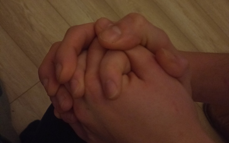 Dwie dłonie splecione razem, symbolizujące wsparcie i bliskość.