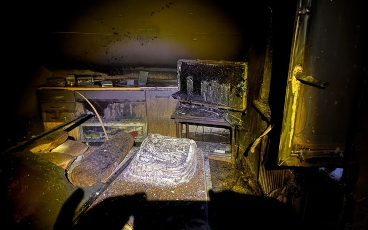 Zniszczone wnętrze po pożarze, z popiołem i zniszczeniami.
