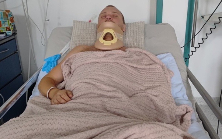 Mężczyzna leżący w szpitalnym łóżku, w trakcie rehabilitacji.