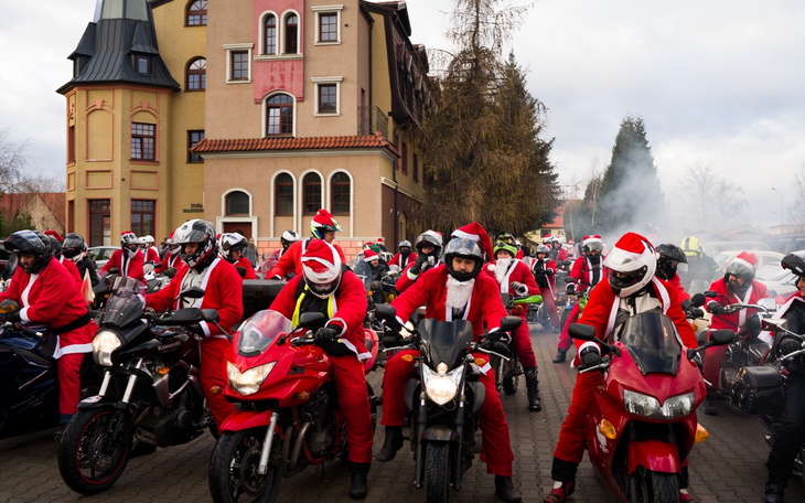 Grupa motocyklistów przebranych za Mikołajów na motocyklach.