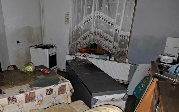 Zniszczone wnętrze mieszkania z meblami i sprzętem.