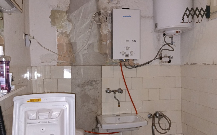 Widok na kuchnię z piecykiem i zlewem, w trakcie remontu.