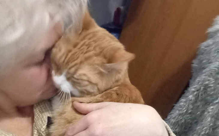 Kobieta przytulająca kota, oboje wyglądają na szczęśliwych.