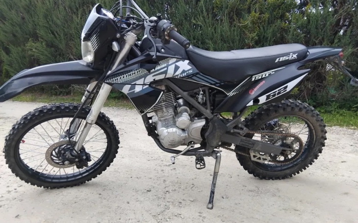 Motocykl terenowy zaparkowany na drodze.
