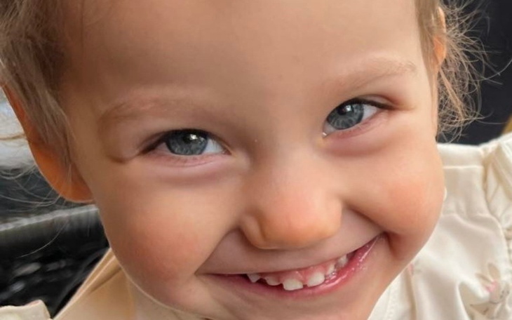 Uśmiechnięta dziewczynka z błyszczącymi oczami.