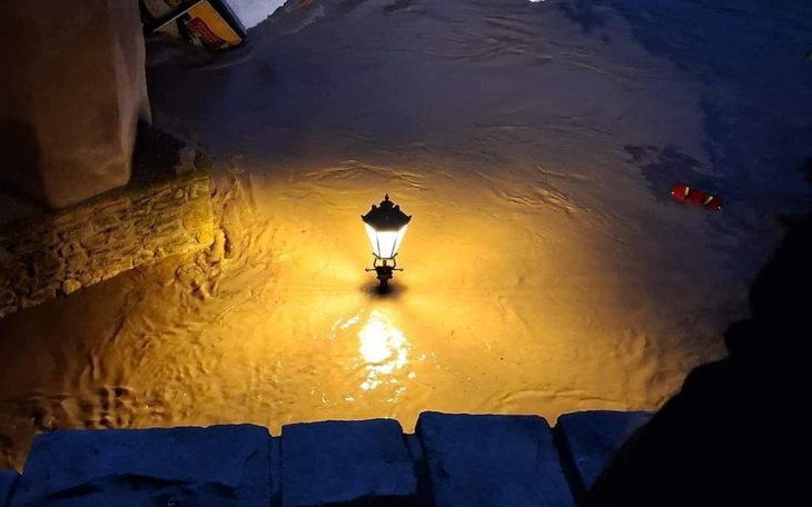 Latarnia oświetlająca zalany teren po intensywnych opadach deszczu.