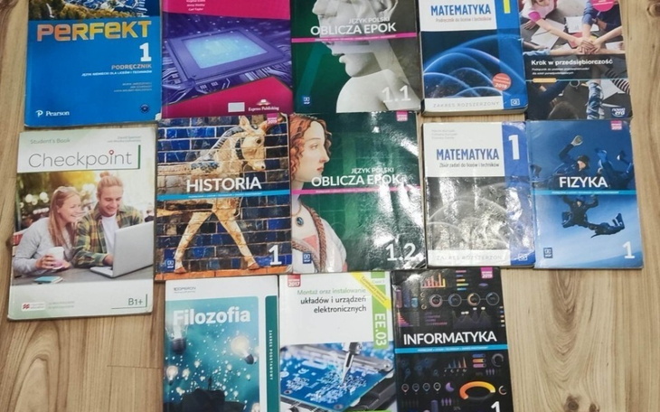 Zestaw podręczników szkolnych na podłodze.