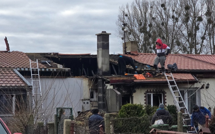 Zniszczony dach domu, ekipa ratunkowa na miejscu zdarzenia.
