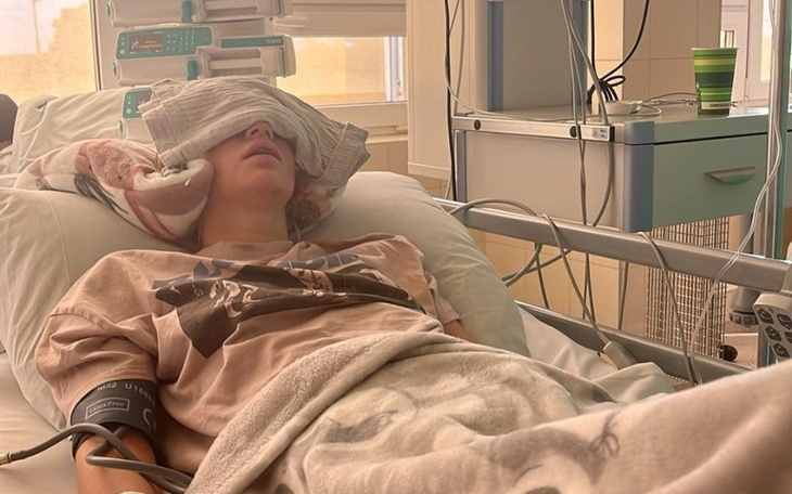 Młody pacjent w szpitalnym łóżku z opaską na oczach.