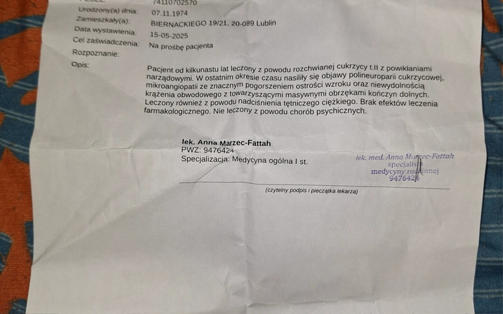 Chłopiec w pomarańczowej kurtce na tle kwiatów.