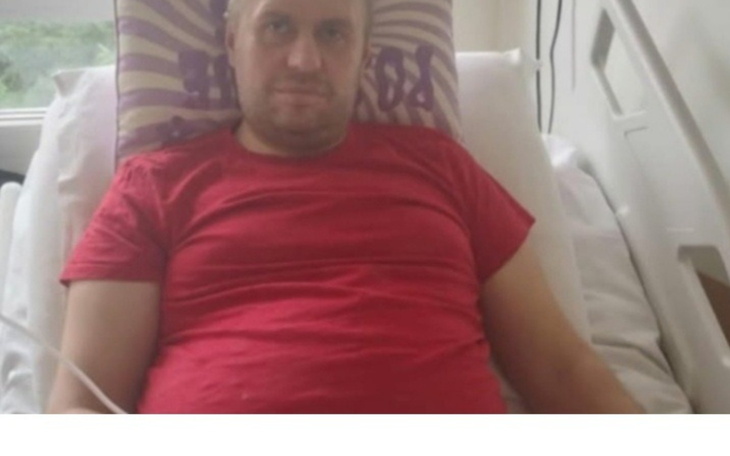 Mężczyzna leżący w łóżku szpitalnym, wygląda na zmęczonego.