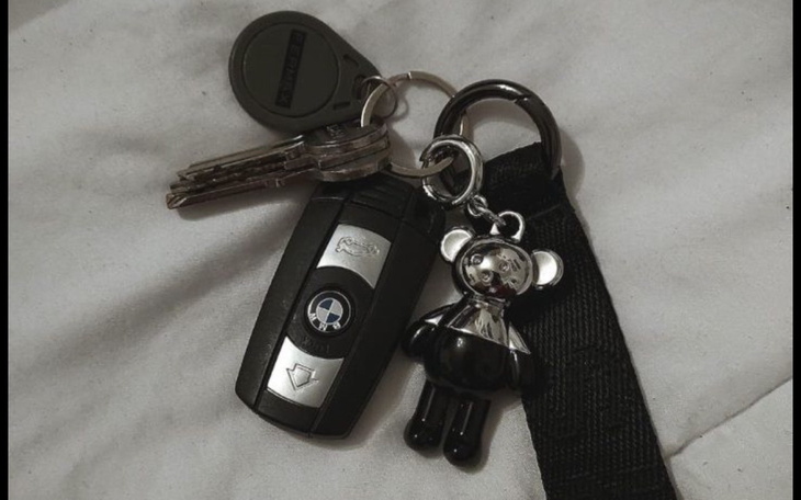 Klucze z breloczkiem w kształcie misia na tle pościeli.