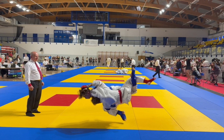 Zawodnicy judo w trakcie emocjonującej walki na macie.