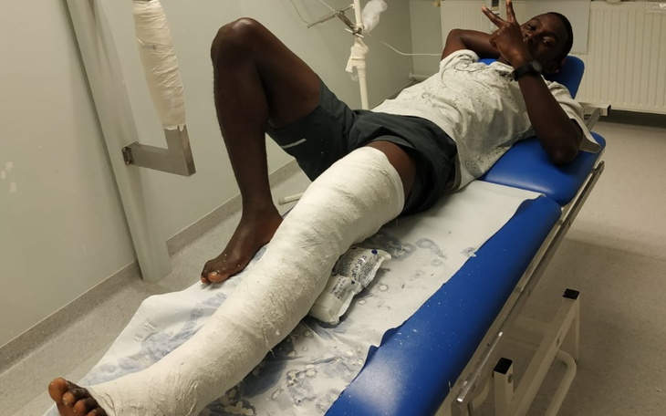 Mężczyzna z unieruchomioną nogą, leżący na łóżku szpitalnym.