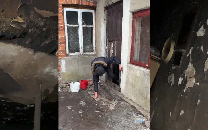 Osoba wchodząca przez małe drzwi do zniszczonego budynku.